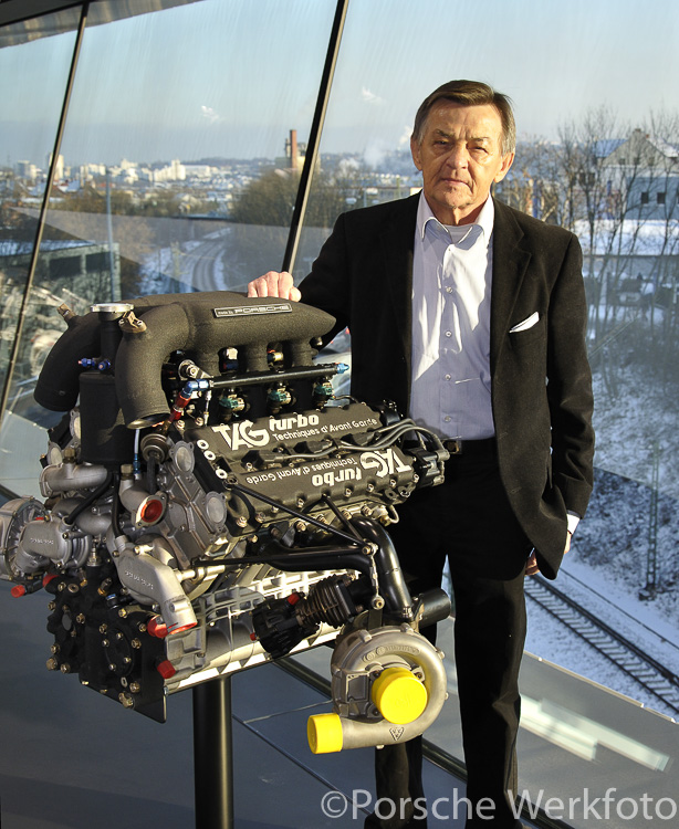 Hans Mezger stands proudly with the TAG McLaren Formula One engine in the Porsche Museum