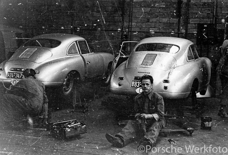 Race mechanic, Eberhard Storz (right), works on one of the Porsche 356 SLs