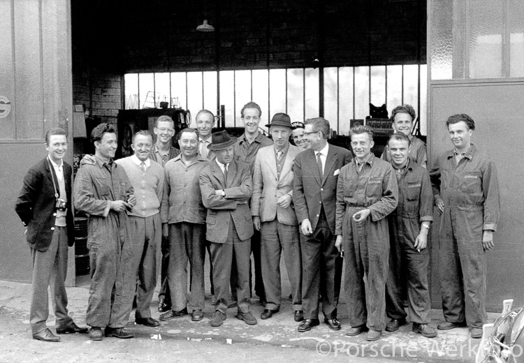 This photo shows Ferry Porsche and workshop manager Georges Debré (both wearing hats) with Baron Huschke von Hanstein (to their left) and the racing team