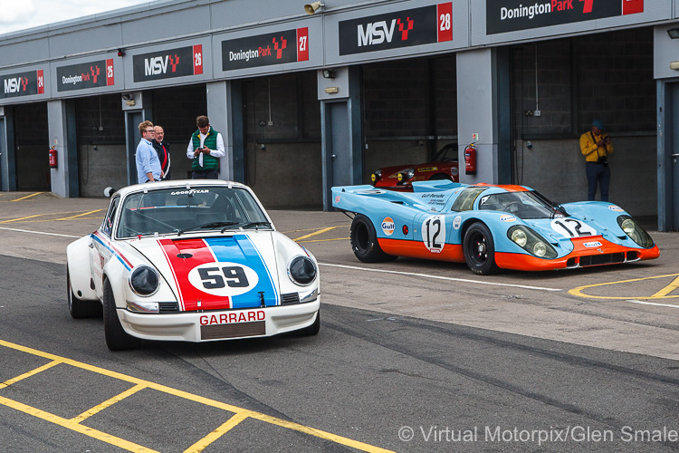 Two of Porsche's most iconic racers - (left) the #59 Porsche 911 Carrera RSR and (right) the #12 Porsche 917-008 in the paddock