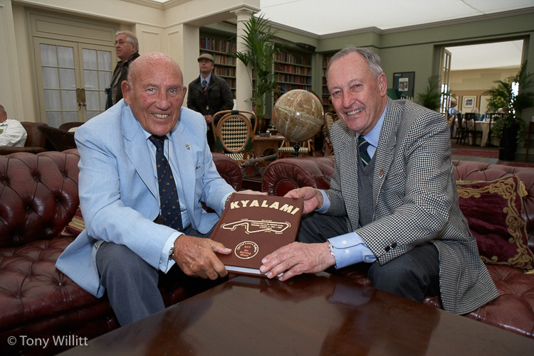 André Loubser hands a copy of his book ‘Kyalami’ to Sir Stirling Moss