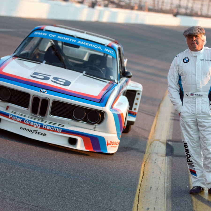 Brian Redman standing next to Porsce on track at Targa Sixty Six