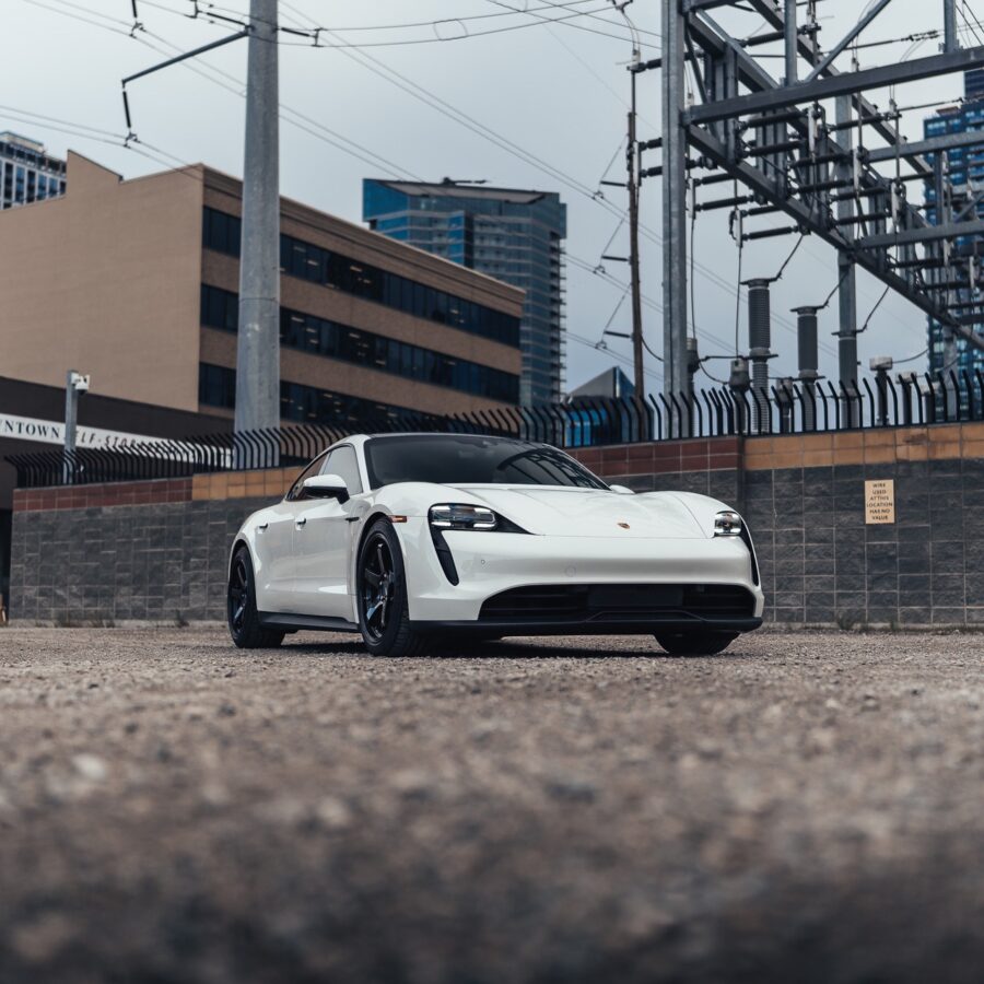 White Porsche Taycan electric car in industrial area